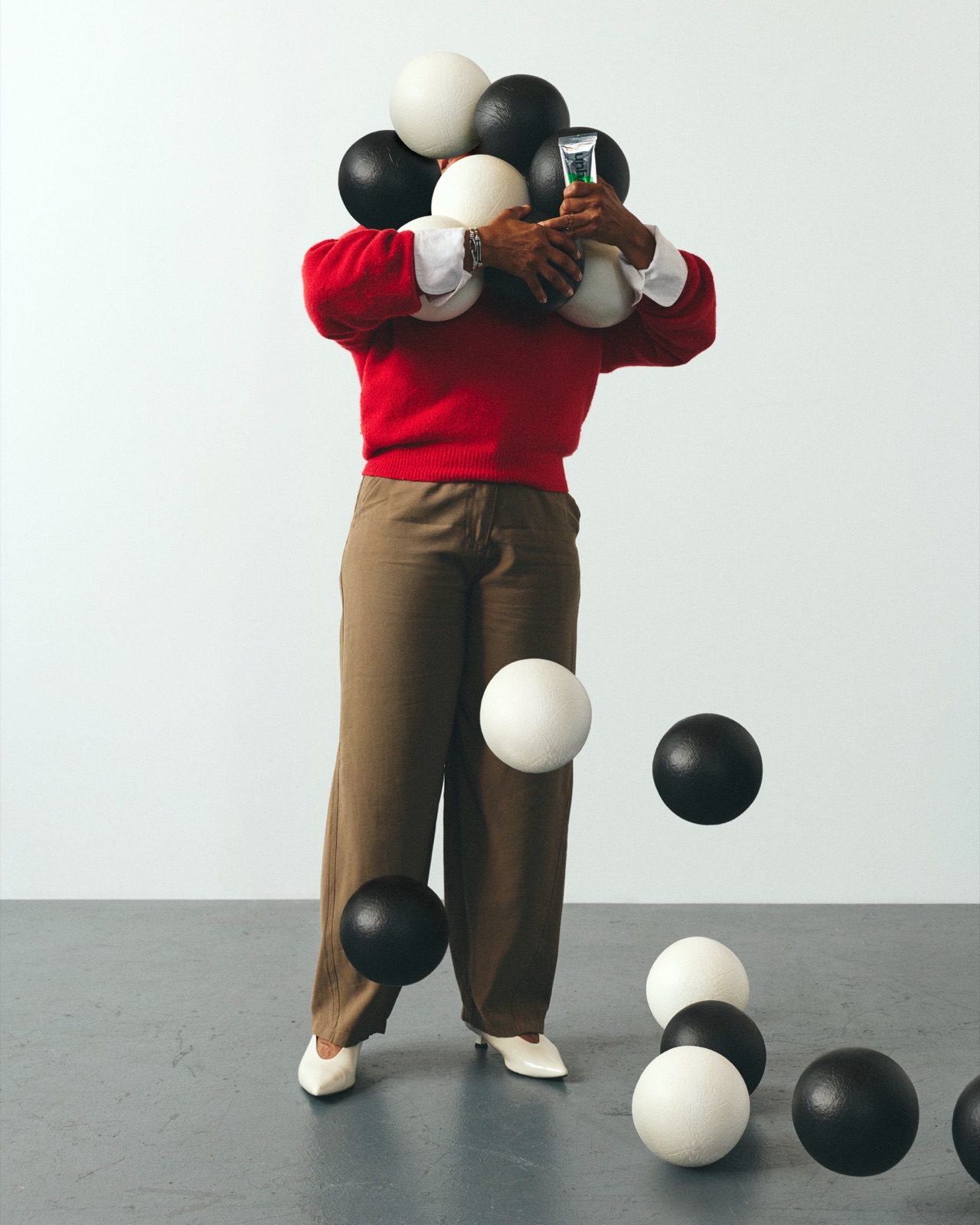 Diane in a red sweater juggling a cloud of black and white balls