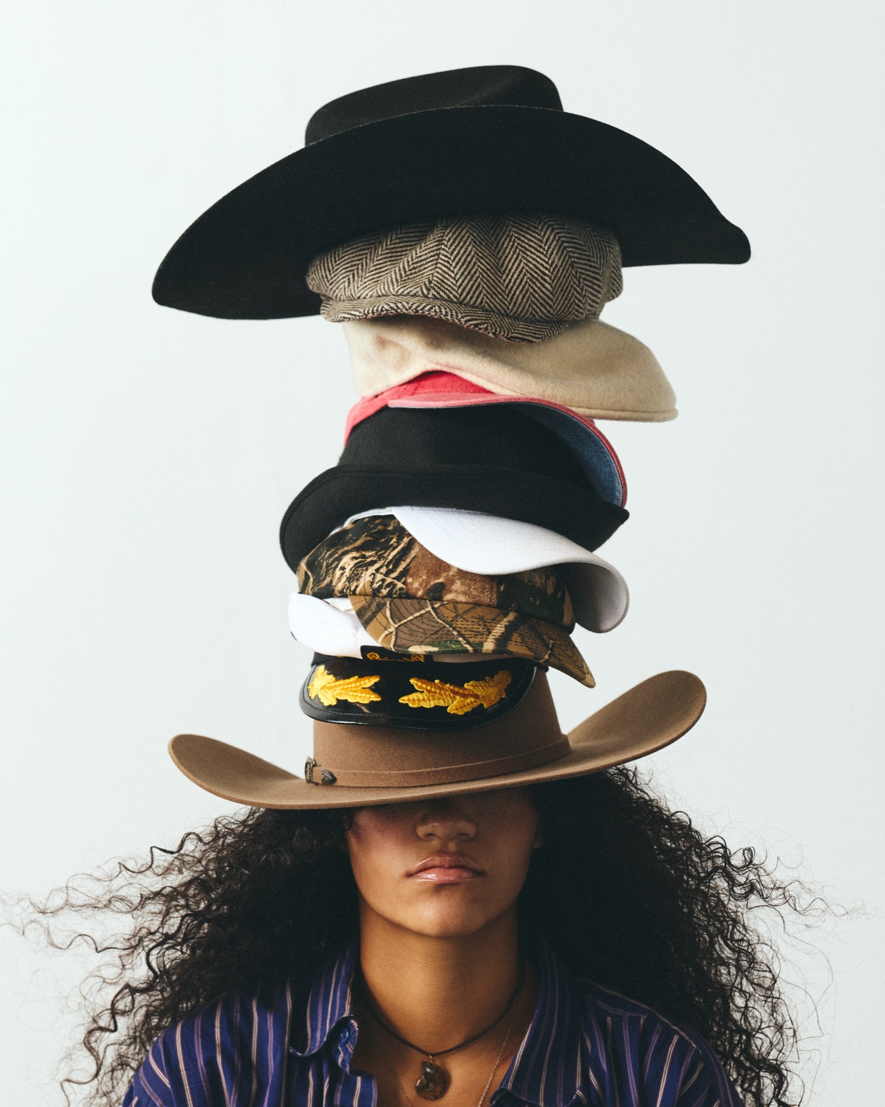 Malia wearing a towering stack of hats pulled down over her eyes